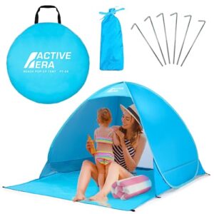 Active Era Pop Up Strandmuschel in Blau, idealer Sonnenschutz mit UPF 50+, für 2-3 Personen, im Hintergrund eine entspannte Familie am Strand.
