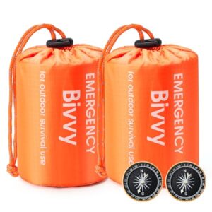 Zwei orangefarbene Notfall-Biwaksäcke verpackt in einer kompakten Form, ideal für Outdoor-Survival und Notfallsituationen, inklusive zwei Kompassen zur Orientierung.