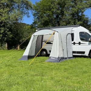 Freizeitschmiede Arc-260 Vorzelt für Wohnwagen und Wohnmobil, 260x220 cm, grau, auf grüner Wiese mit stabilen Seitenstangen und offenen Frontbereich.
