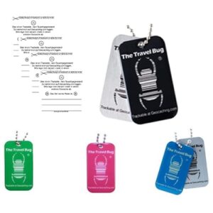 Vier verschiedene Geocaching Travel Bug Tags in Schwarz, Pink, Blau, Grün und Rot, die zur Verfolgung von Abenteuern und Schätzen in der Natur verwendet werden können.
