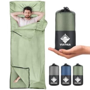 Mann liegt entspannt in einem grünen Hüttenschlafsack aus Mikrofaser, ideal für Camping und Reisen, gut sichtbar mit zwei-Wege-Reißverschluss für individuelles Komfort.