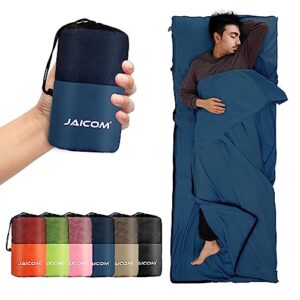 Ultraleichter Hüttenschlafsack aus Mikrofaser mit dunkler und heller blauer Farbgestaltung, ideal für Rucksackreisen und Hotels. Im Vordergrund eine Hand hält den gefalteten Schlafsack, im Hintergrund ein Mann entspannt sich eingekuschelt in den Schlafsack auf einer Schlafmatte.