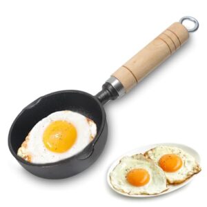 Kleine Gusseisenpfanne mit Holzgriff und gebratenem Ei, perfekt für Spiegeleier und kleine Portionen, hitzebeständig und antihaftbeschichtet.
