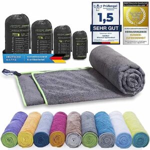 LightDry Original Mikrofaser Sporthandtuch, zusammen gerollt in grau mit grüner Naht, umgeben von weiteren Handtüchern in verschiedenen Farben, perfekt für Sport, Fitness und Reisen