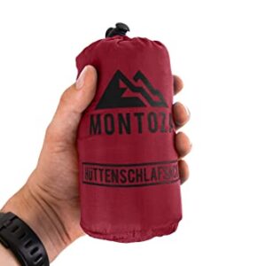 Ultraleichter roter Hüttenschlafsack aus Seide und Baumwolle, ideal für Reisen und Camping. Kompakt verpackt in einer Hand gehalten.