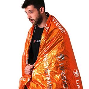 Junger Mann eingewickelt in eine orangefarbene Notfall-Wärmedecke aus Silberfolie, ideal für Outdoor-Aktivitäten wie Wandern und Bergsteigen, mit einem ernsthaften Gesichtsausdruck vor neutralem Hintergrund.
