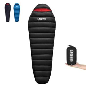QEZER ultraleichter Daunenschlafsack in Schwarz mit roter Innenfarbe, ideal für Kinder und Erwachsene beim Camping und Trekking, in komprimiertem Zustand in der Hand gehalten.