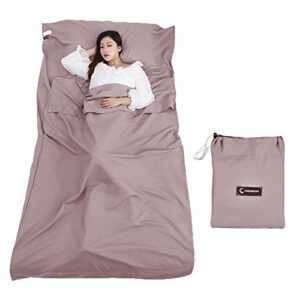 Person in einem braunen Hüttenschlafsack, der Komfort und Hygiene für Reisen bietet, elegant und praktisch für Outdoorsituationen.