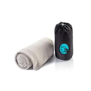 Kuscheldecke aus Fleece in hellem Grauton, zusammengelegt und in einem schwarzen Tragetasche mit Kordelzugverschluss, ideal für Reisen und Outdoor-Aktivitäten