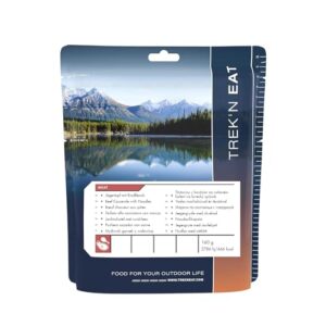 Trek'n Eat Jägertopf mit Rindfleisch und Nudeln 'Försterin' für Outdoor-Aktivitäten, verpackt in ansprechendem Design mit Berglandschaft im Hintergrund.