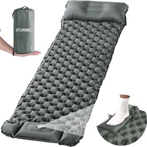 Selbstaufblasende Camping-Isomatte in Grau mit integriertem Kopfkissen und Fußpumpe für Outdoor-Aktivitäten, robust und leicht transportierbar.