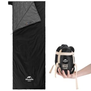 Ultraleichter Sommerschlafsack in Schwarz mit grauer Innenseite, ideal für Camping und Wandern, zusammengehalten in einem kompakten Transportbeutel.