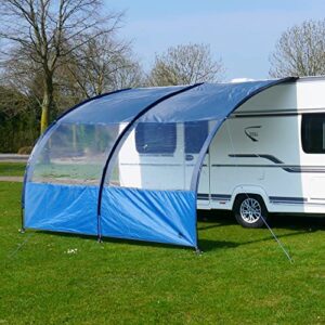 your GEAR Riviera Vorzelt für Wohnwagen und Wohnmobile mit transparenten Wänden und blauen Akzenten, stabil aufgebaut auf einer grünen Wiese an einem sonnigen Tag.