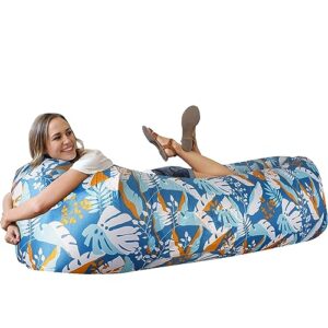 Frau entspannt auf einer bunten aufblasbaren Couch im Freien, ideal für Camping und Strand, mit tropischem Design in lebhaften Farben.