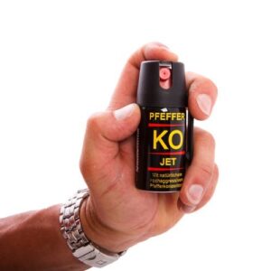 Ballistol Pfeffer-KO Jet Aerosoldose in der Hand eines Menschen. Das Spray ist handlich, hat eine gelbe Beschriftung und ist ideal für Selbstverteidigung. Hintergrund einheitlich weiß.
