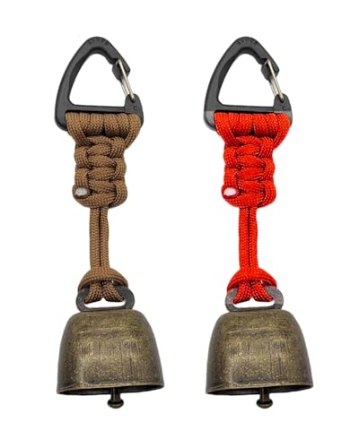 Zwei metallene Glocken in verschiedenen Farben, eine mit silbernen Klapper im Zentrum, auf einem grauen Hintergrund. Die Glocken sind für Outdoor-Anwendungen wie Wanderungen oder als Halsband für Haustiere geeignet.