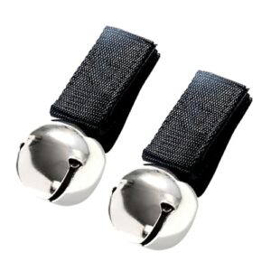 Zwei magnetische Baerglocken sitzen neben einander. Die Glocken sind an einem schwarzen Band befestigt. Das Bild zeigt zwei silberne und schwarze magnetische Baerglocken.