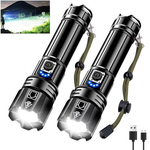 Zwei schwarze Taschenlampen mit blauen Knöpfen und Ladeanschlüssen. Die Lampen sind an einem USB-Kabel angeschlossen. Ein weißer Etikett auf der Lampen, die im Hintergrund unter dem Nachthimmel unter einer Bergkulisse stehen.