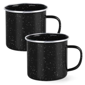 Zwei schwarze Emaille-Camping-Mugge mit Flecken auf einem weißen Hintergrund. Der Griff ist auch schwarz und es hat ein kleines Loch in der oberen rechten Ecke. Die Tasse auf der linken Seite ist leicht hinter der auf der rechten Seite.